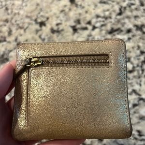 Used gold Fossil mini wallet. RFID Blocking. Has minor tears and lipstick stain.